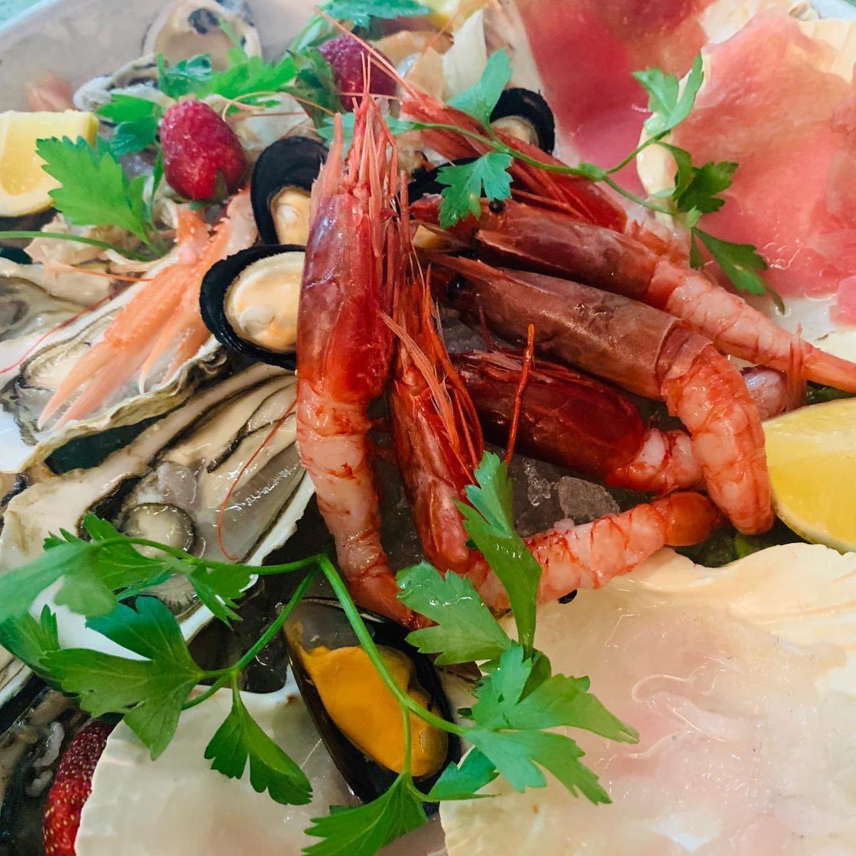 Un primo piano di un piatto di cibo con gamberetti e ostriche