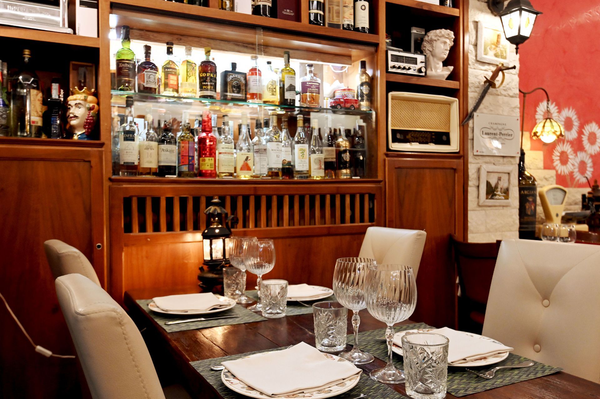 Un ristorante con un bar e un tavolo con piatti e bicchieri sopra