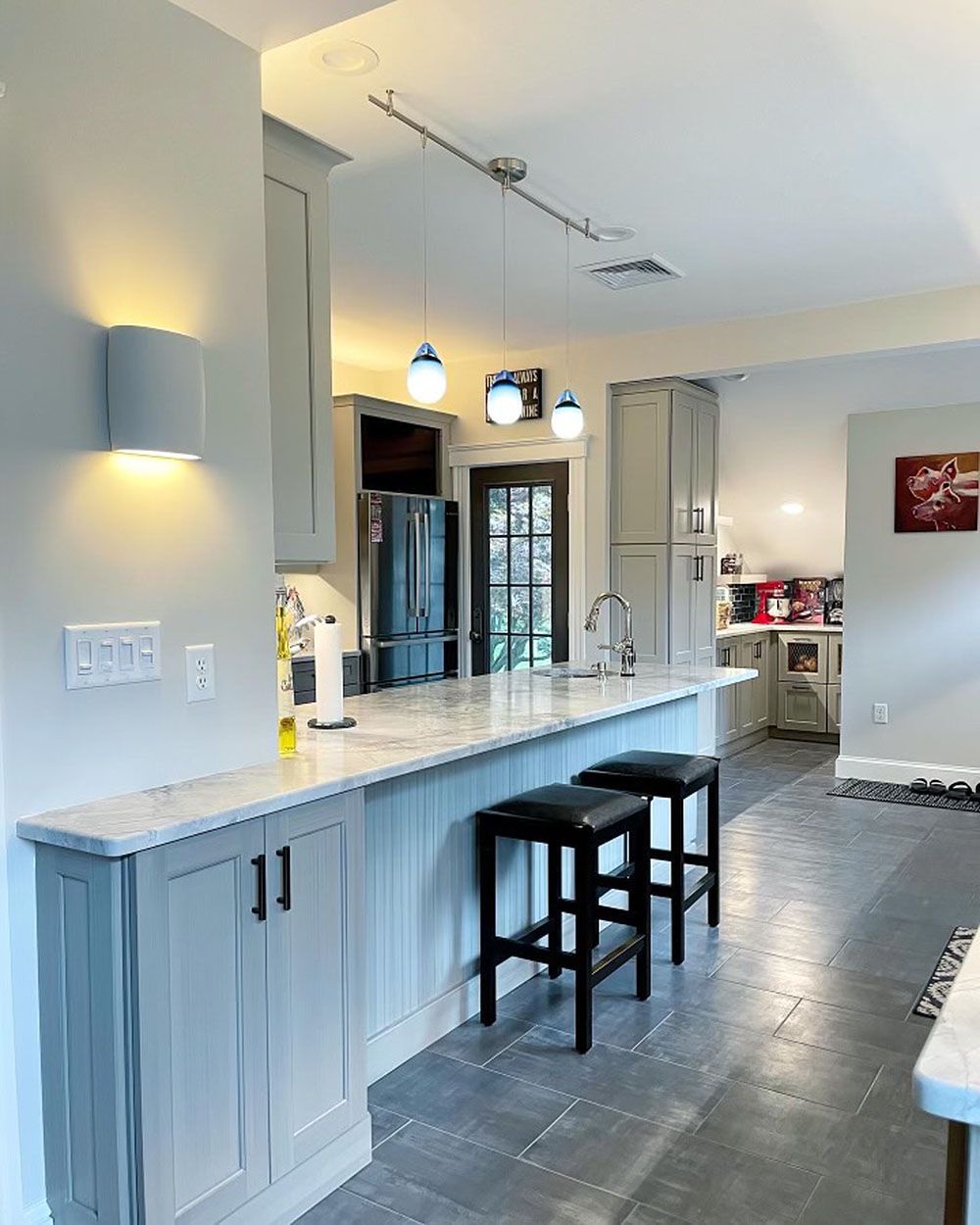 A kitchen with a long island and two stools.