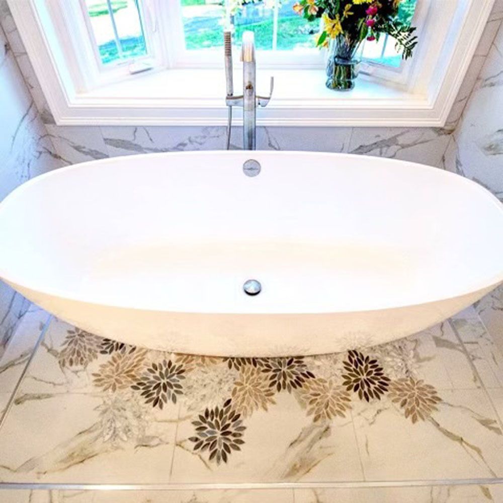 A bathtub is sitting on a tiled floor in a bathroom next to a window.