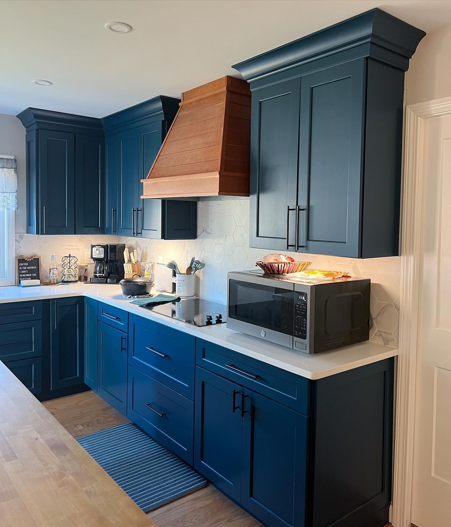A kitchen with blue cabinets and a microwave on the counter
