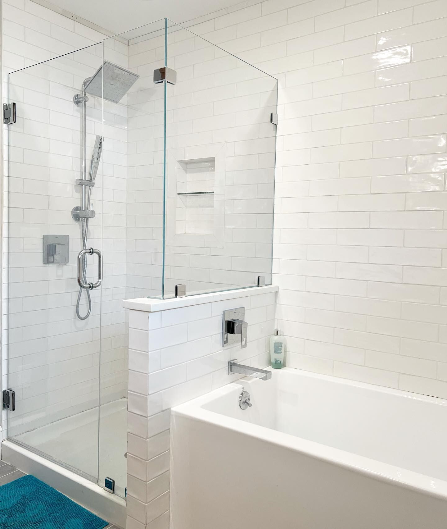 A bathroom with a bathtub , shower , and glass door.