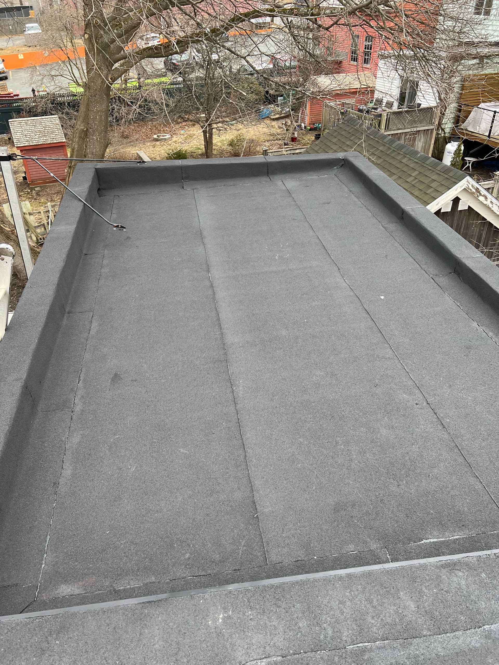 Flat, black roofing with raised edges, outdoors.