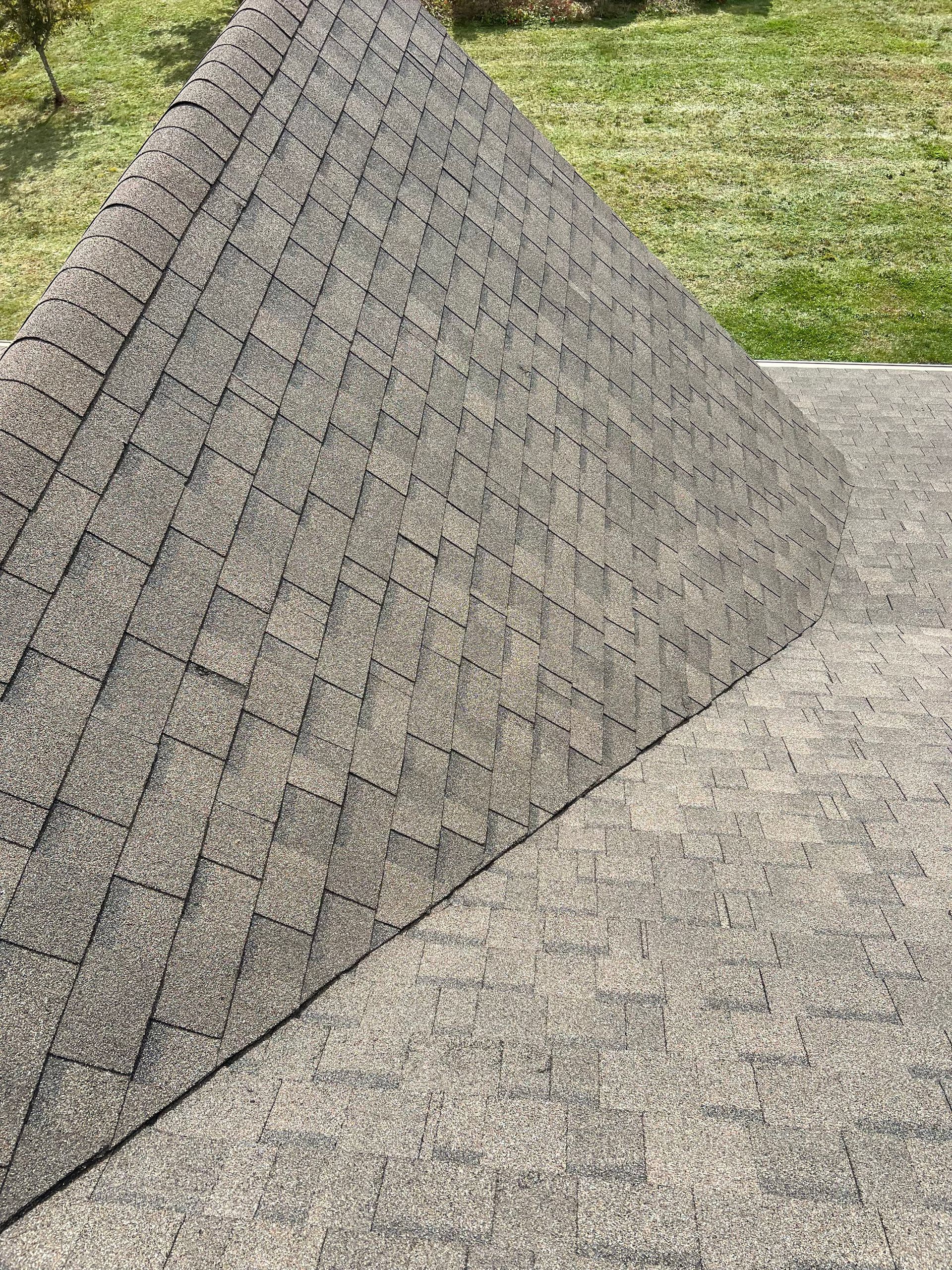 Close-up of a gray, textured roof angled on a flat surface.