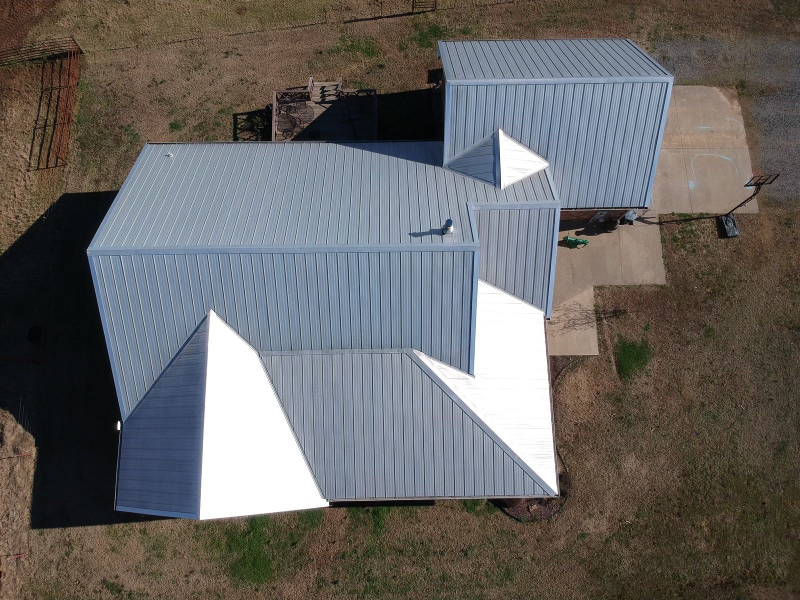 An aerial view of a house with a gray and white roof