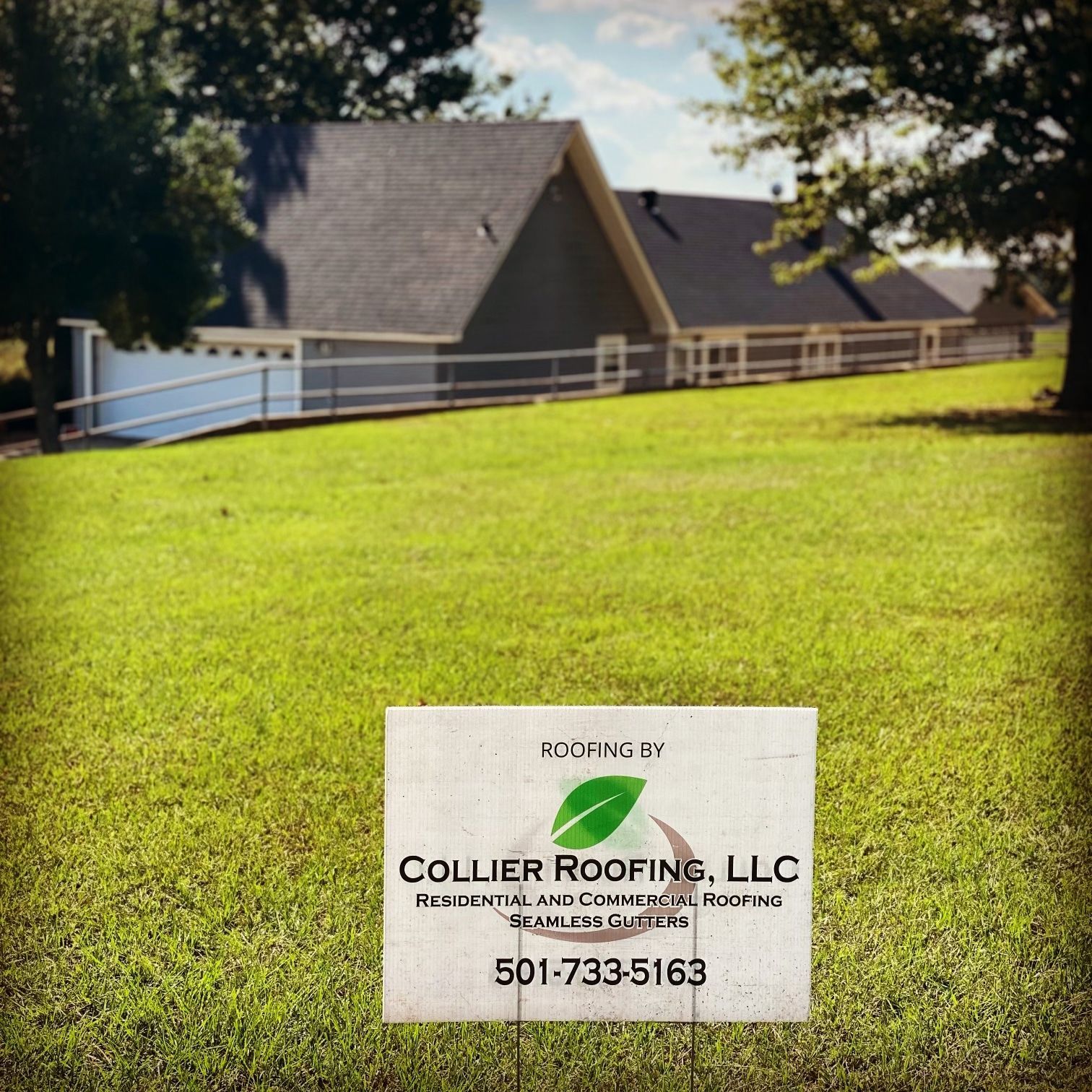 A sign for collier roofing llc is in front of a house