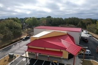 An aerial view of a building with a red roof