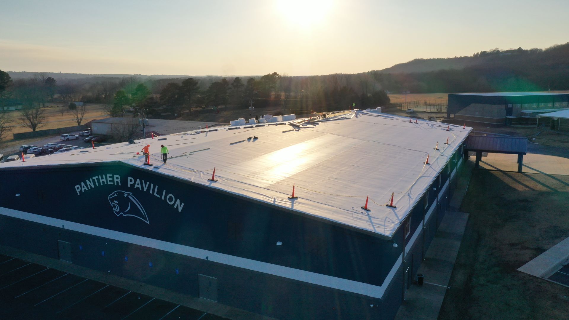 An aerial view of a large building with a white roof.