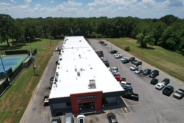 An aerial view of a car dealership with cars parked in front of it