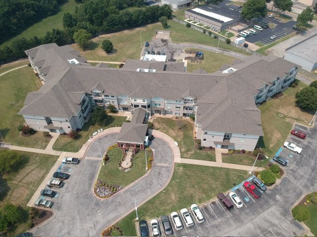 An aerial view of a large building with cars parked in front of it