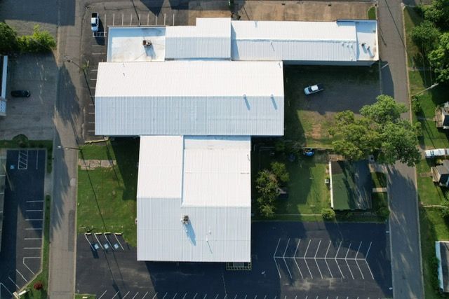 An aerial view of a building with a white roof