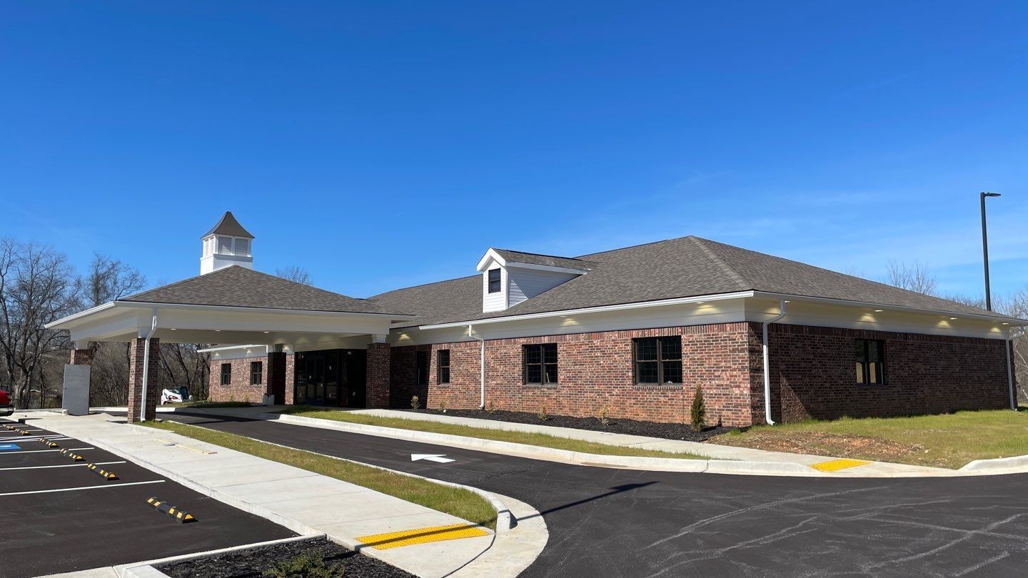 A large brick building with a driveway leading to it.