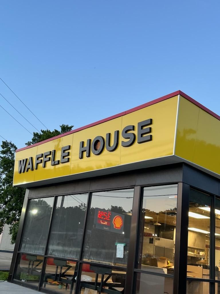 A yellow sign that says waffle house on it
