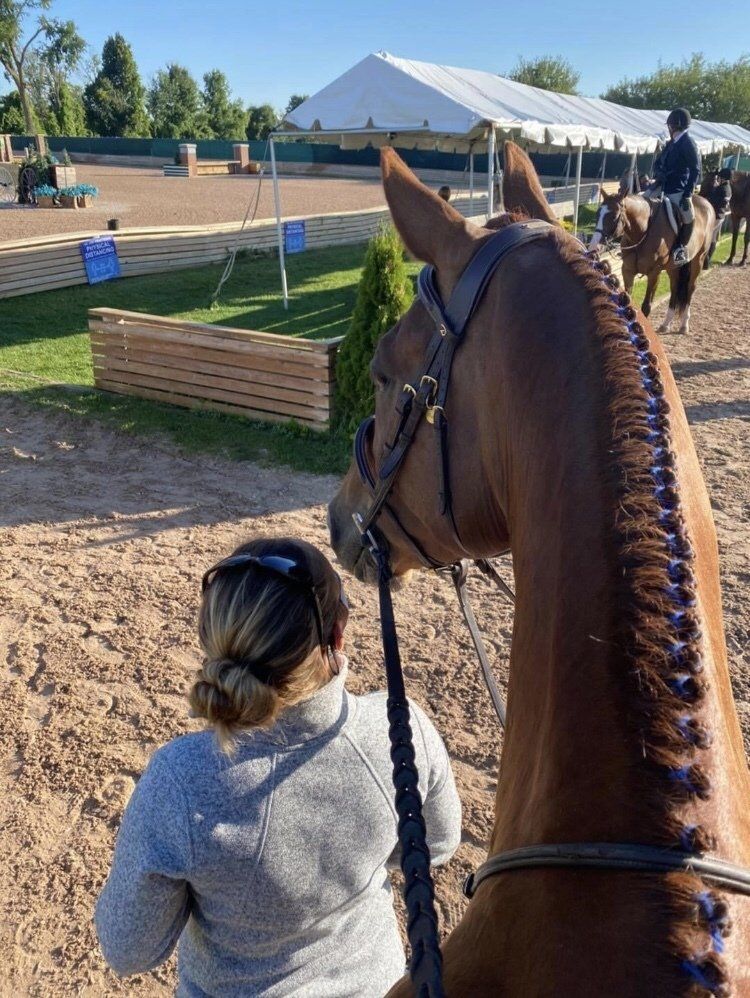 Ashley with one of her student's horses at a horse show