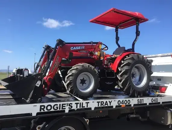 Red Case Ih Tractor with Loader on A Tilt-Tray Truck — Sundance Auto & Machinery Pty Ltd In Airlie Beach, QLD