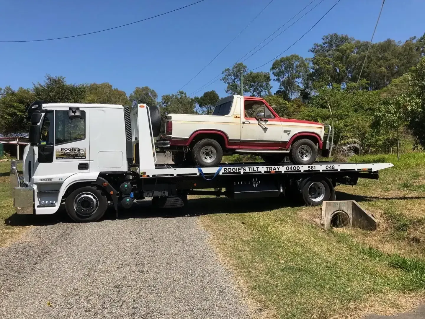 White Tow Truck Carrying a Red and White Vintage Bronco — Sundance Auto & Machinery Pty Ltd In Midge Point, QLD 