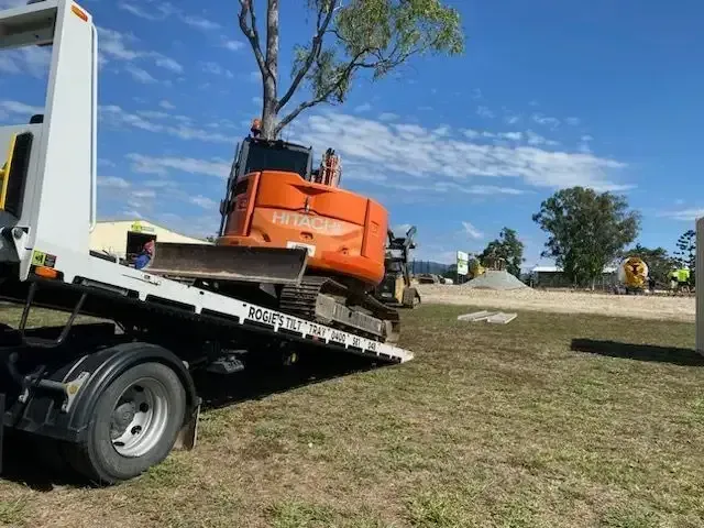 Orange Excavator on A Flatbed Truck at A Construction Site — Sundance Auto & Machinery Pty Ltd In Airlie Beach, QLD 
