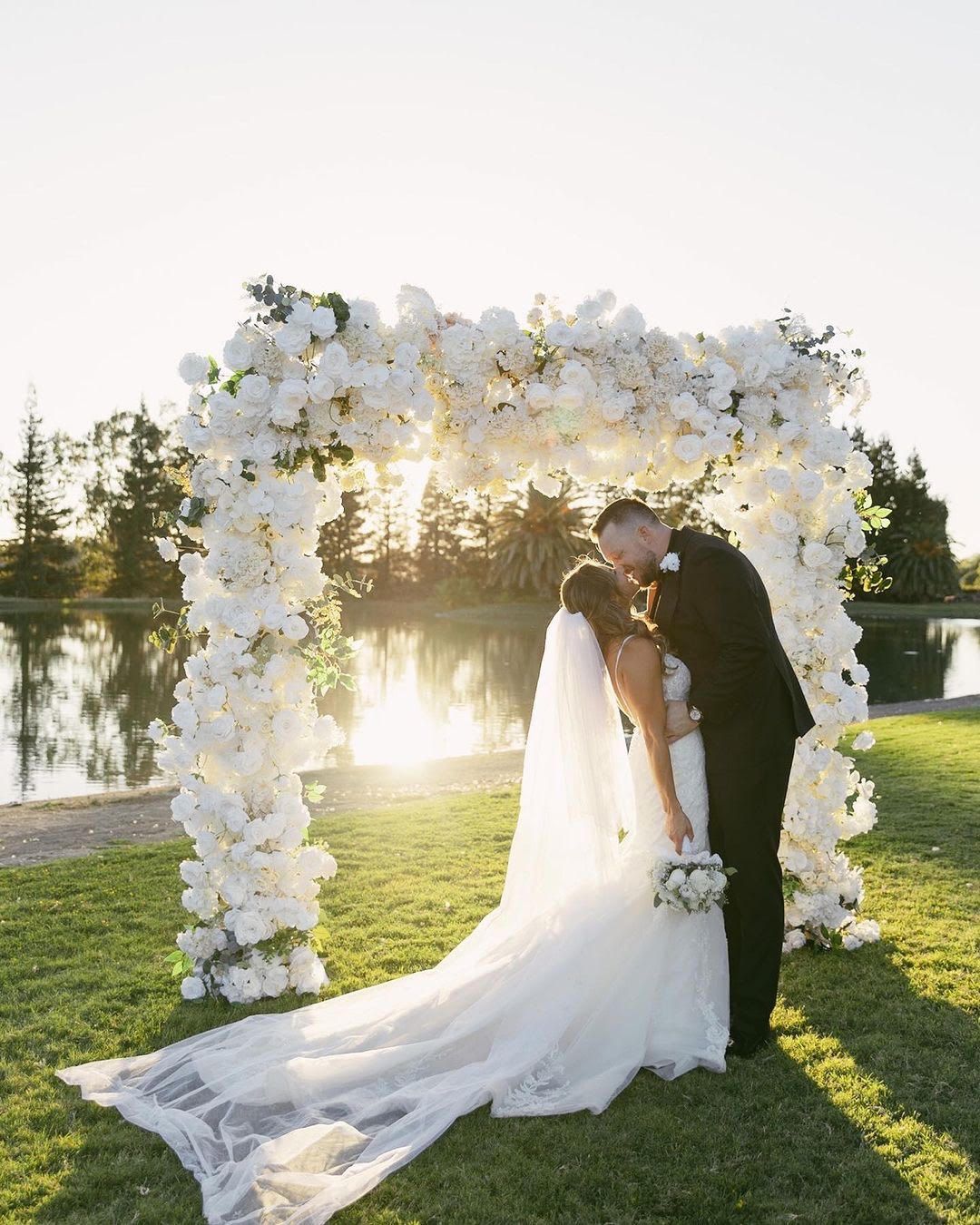 Bride and Groom Kissing in Front of Lake