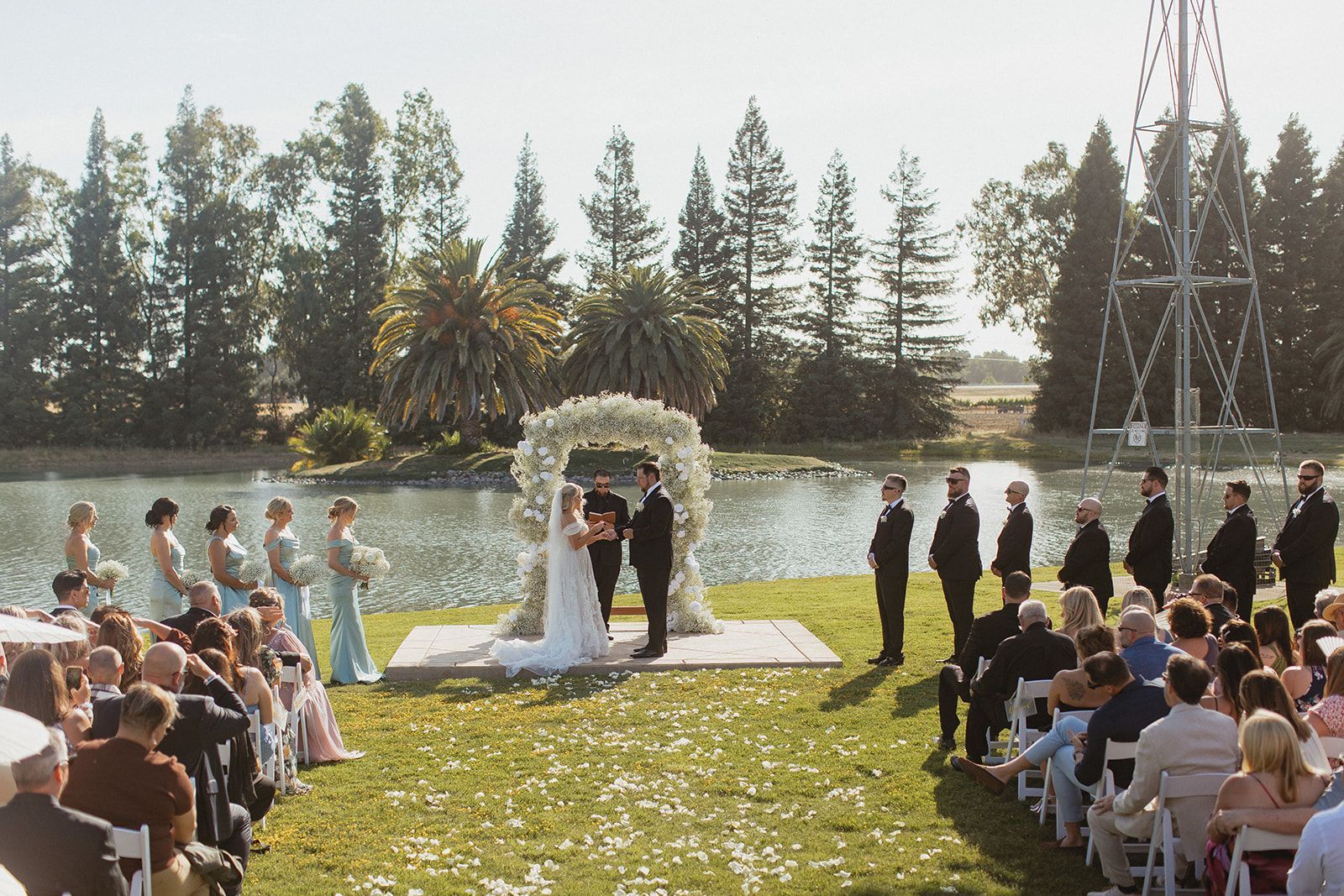 A bride and groom are getting married in front of a lake.