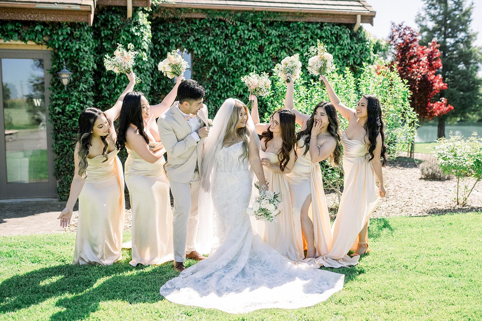 A bride and groom are posing for a picture with their bridesmaids.