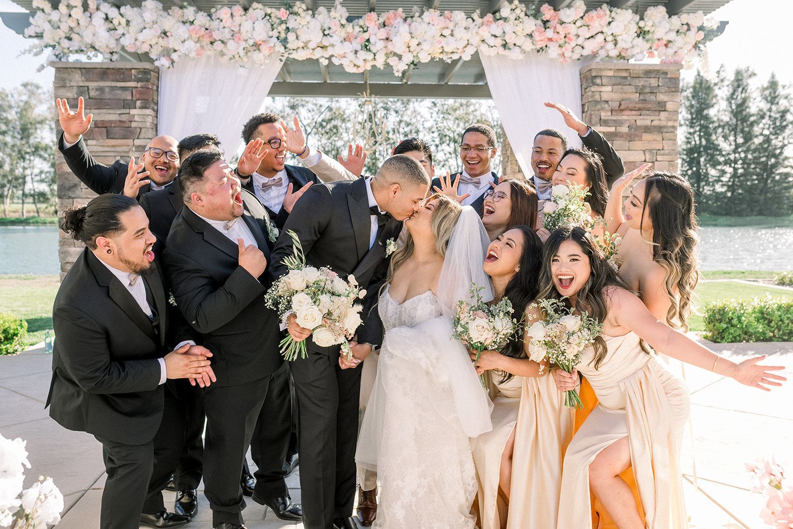 A bride and groom are posing for a picture with their wedding party.