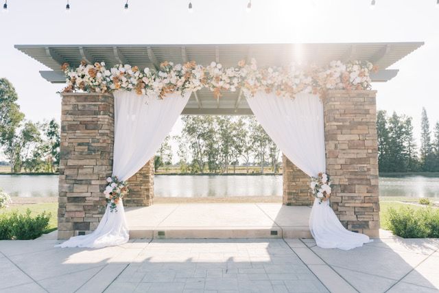 raised stone outdoor alter with brick pattern pillars having a flower arrangement with a lake in the background
