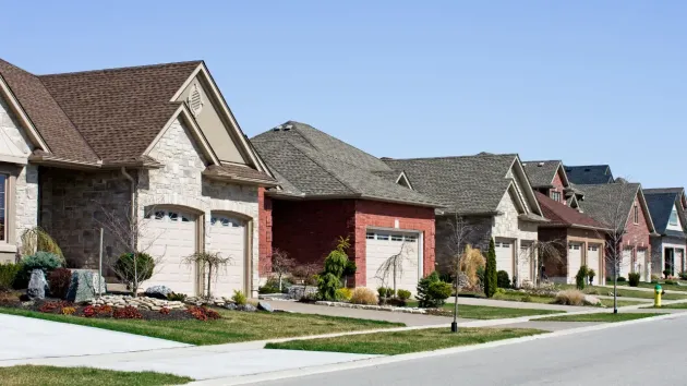 A row of houses are lined up on a residential street.