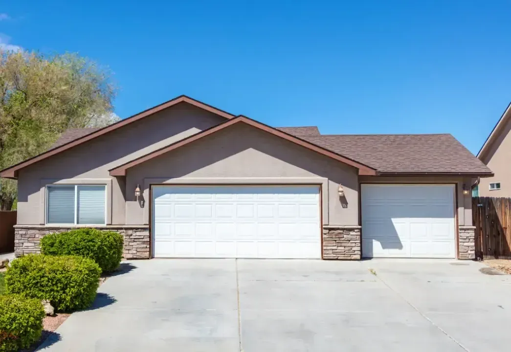 The front of a house with two garage doors and a driveway.