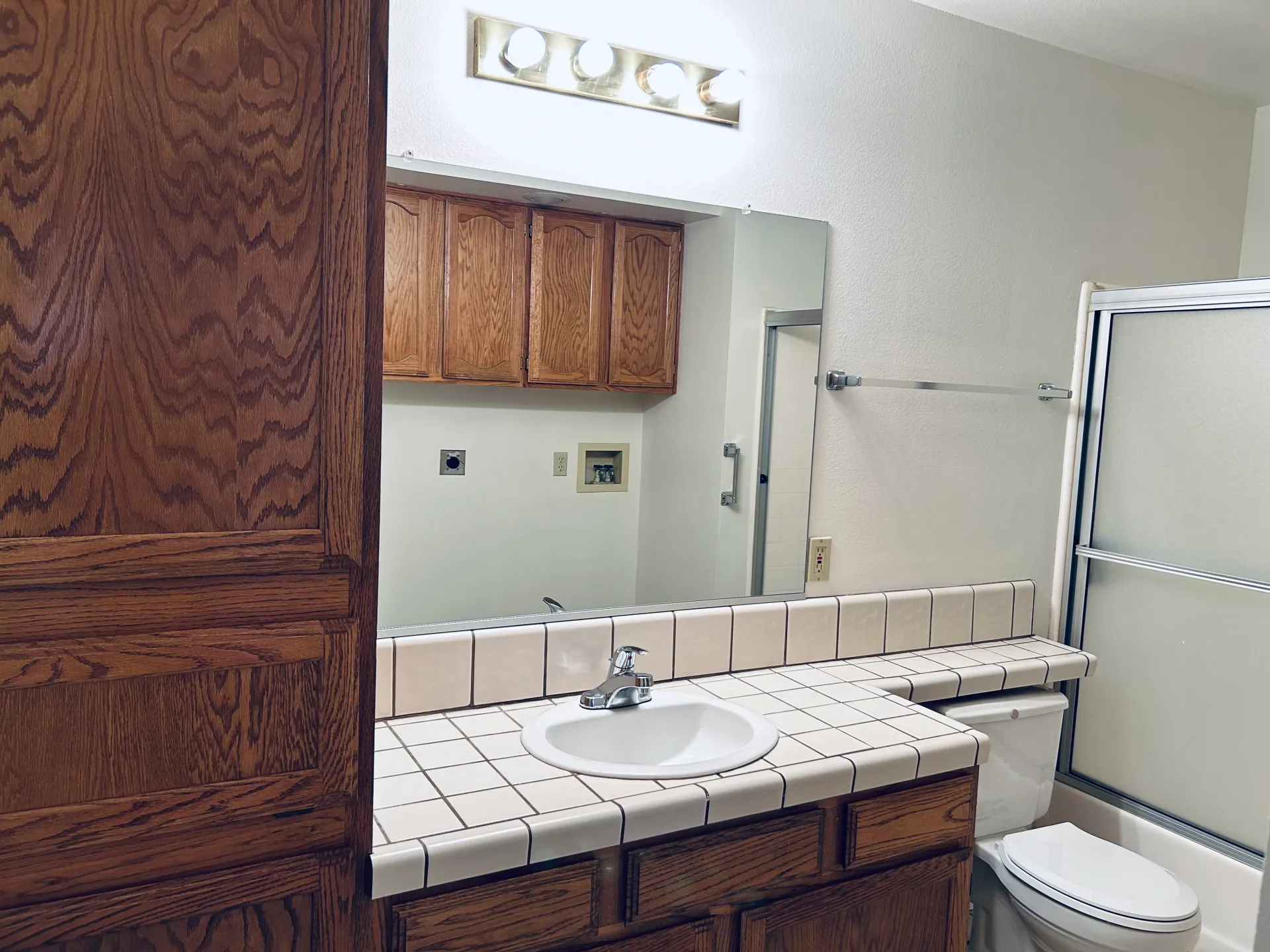 A bathroom with a sink a toilet and a mirror