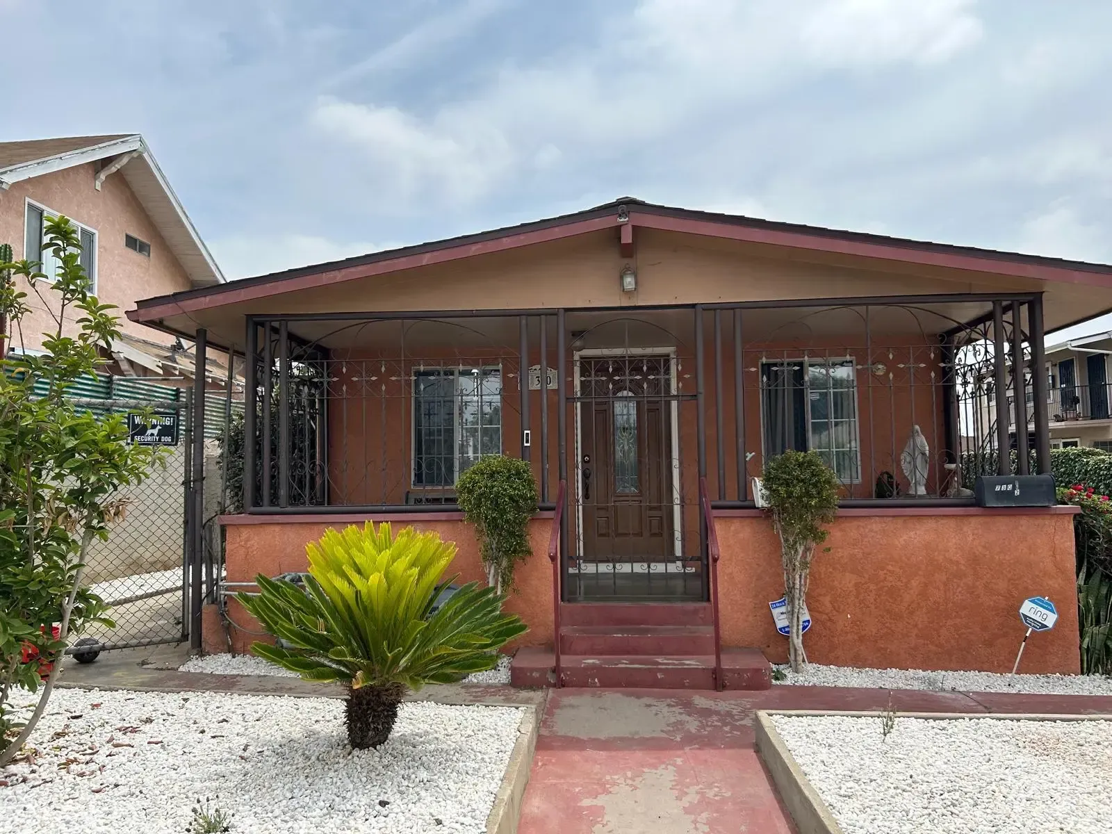 A small house with a porch and a walkway in front of it.
