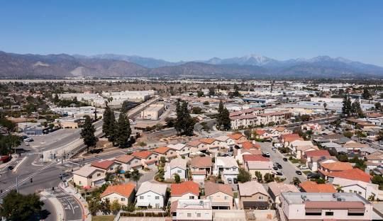 An aerial view of a residential area with mountains in the background.
