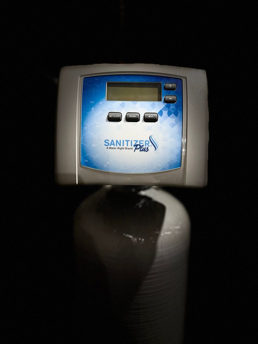 A sanitizer machine is sitting on top of a white tank.