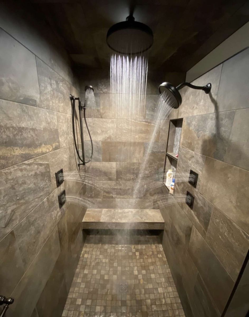 A bathroom with a walk in shower and a shower head.