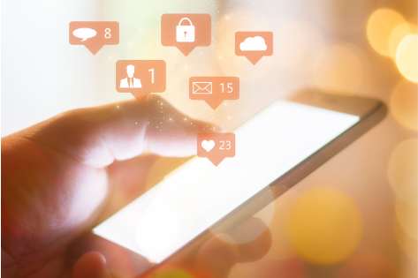 An image of a person holding a smart phone with graphics from social media.