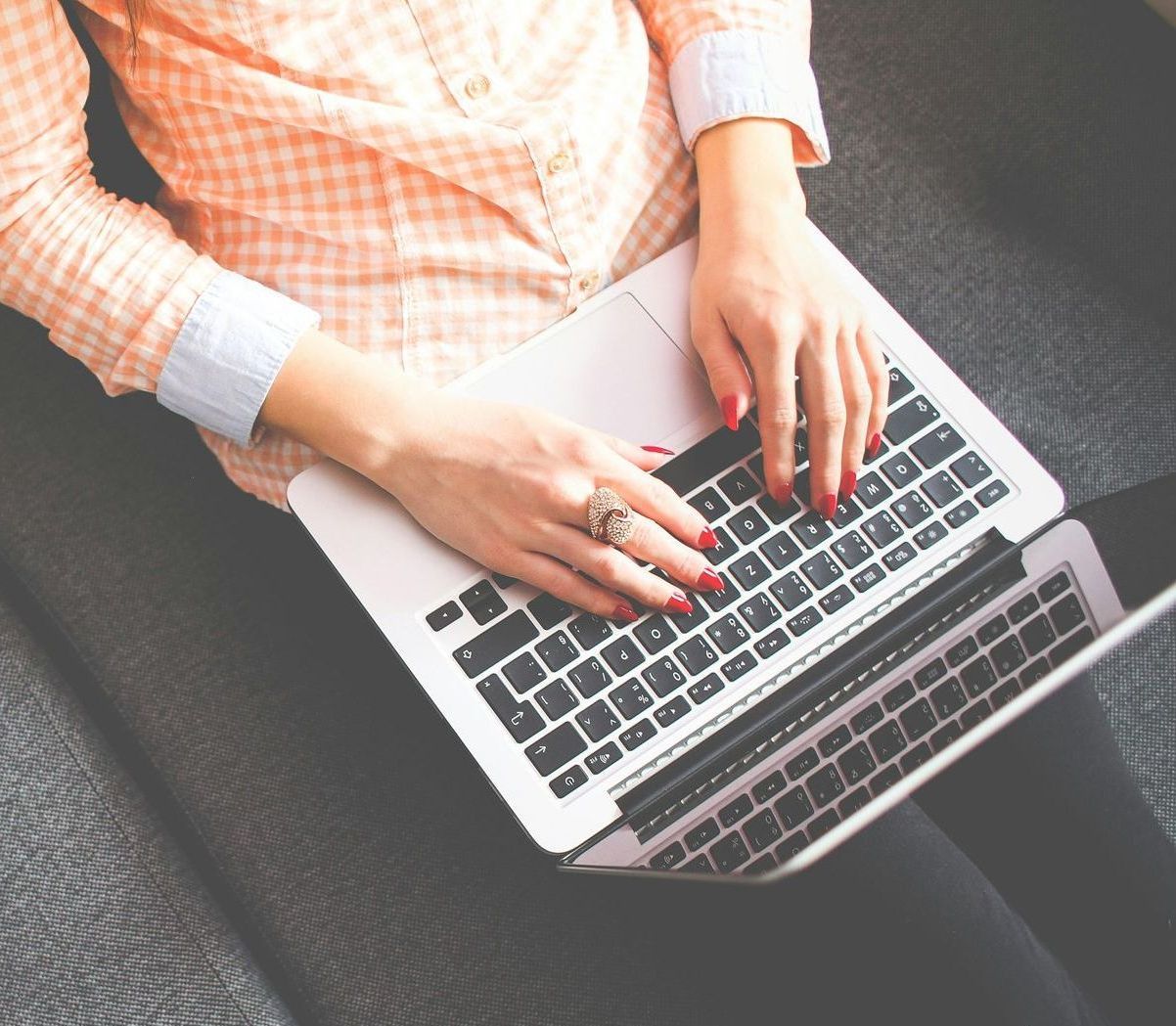 An image of a female typing on a laptop.