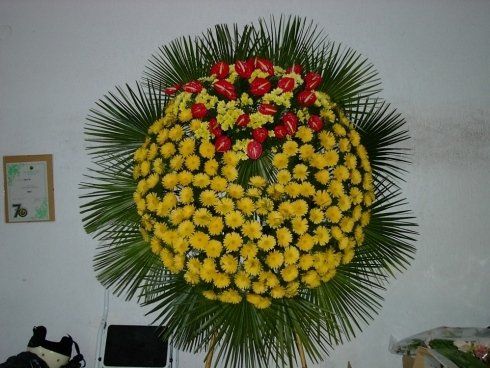 allestimento di fiori gialli e rossi per funerale