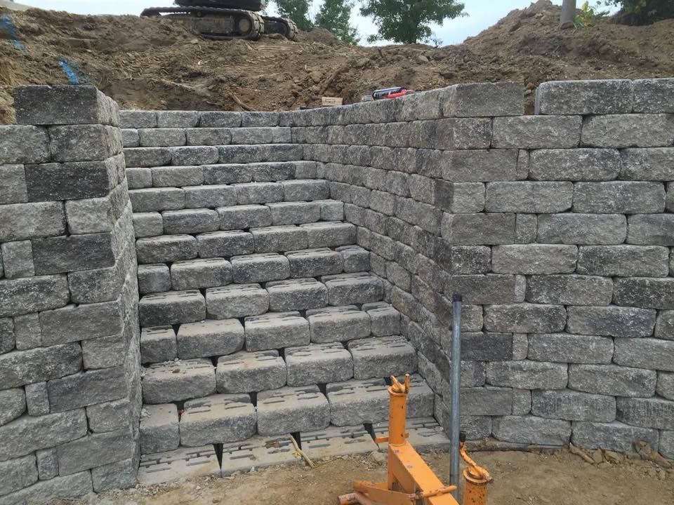 Stone steps built into a retaining wall; outdoor construction site.