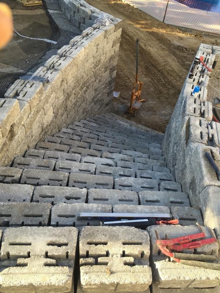 Concrete block stairs being built, leading down a hillside.