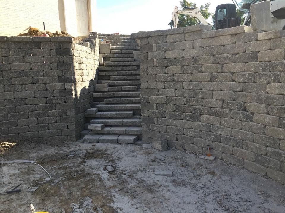 Stone staircase under construction between retaining walls.