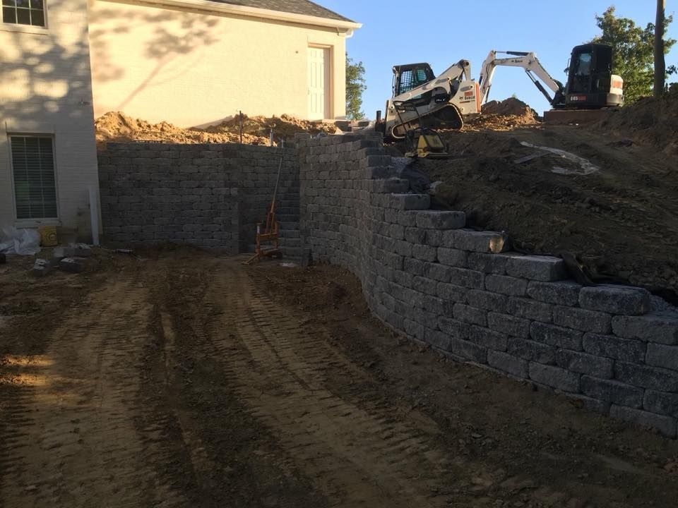 Retaining wall construction; heavy machinery on a hillside.