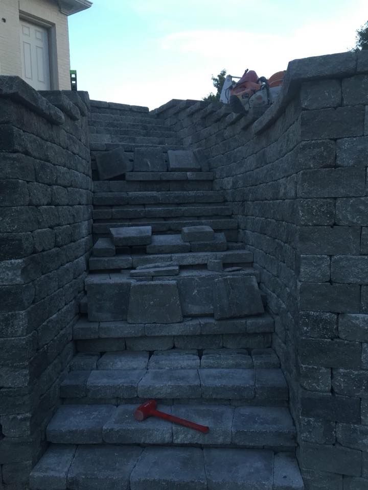 Stone steps leading up a wall. Some steps are loose. Red hammer at the bottom.