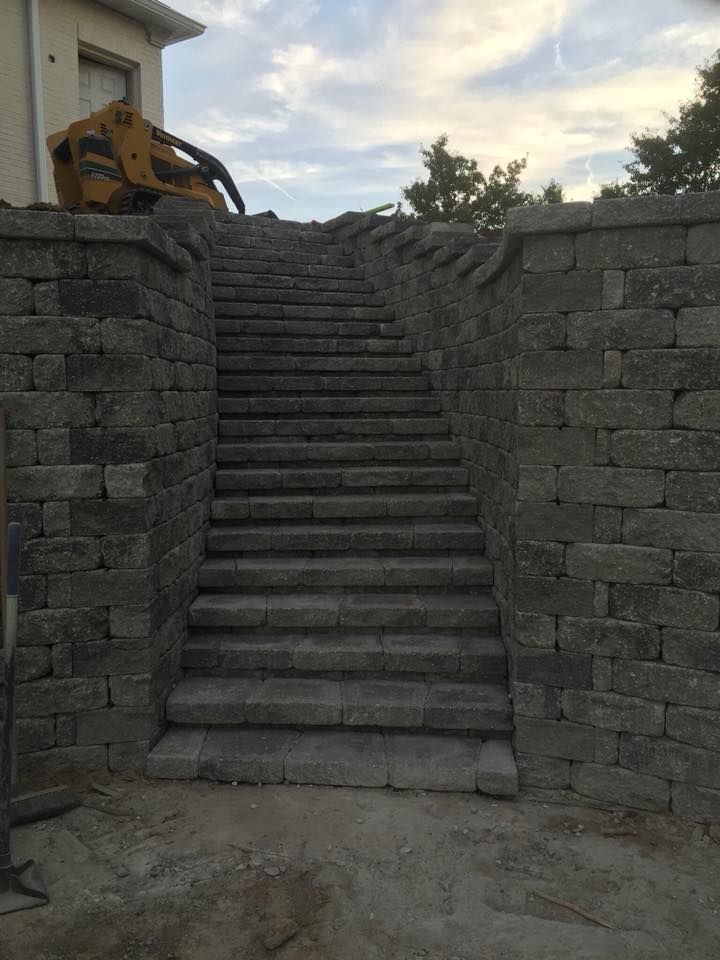 Stone staircase leading up between retaining walls; a construction site.