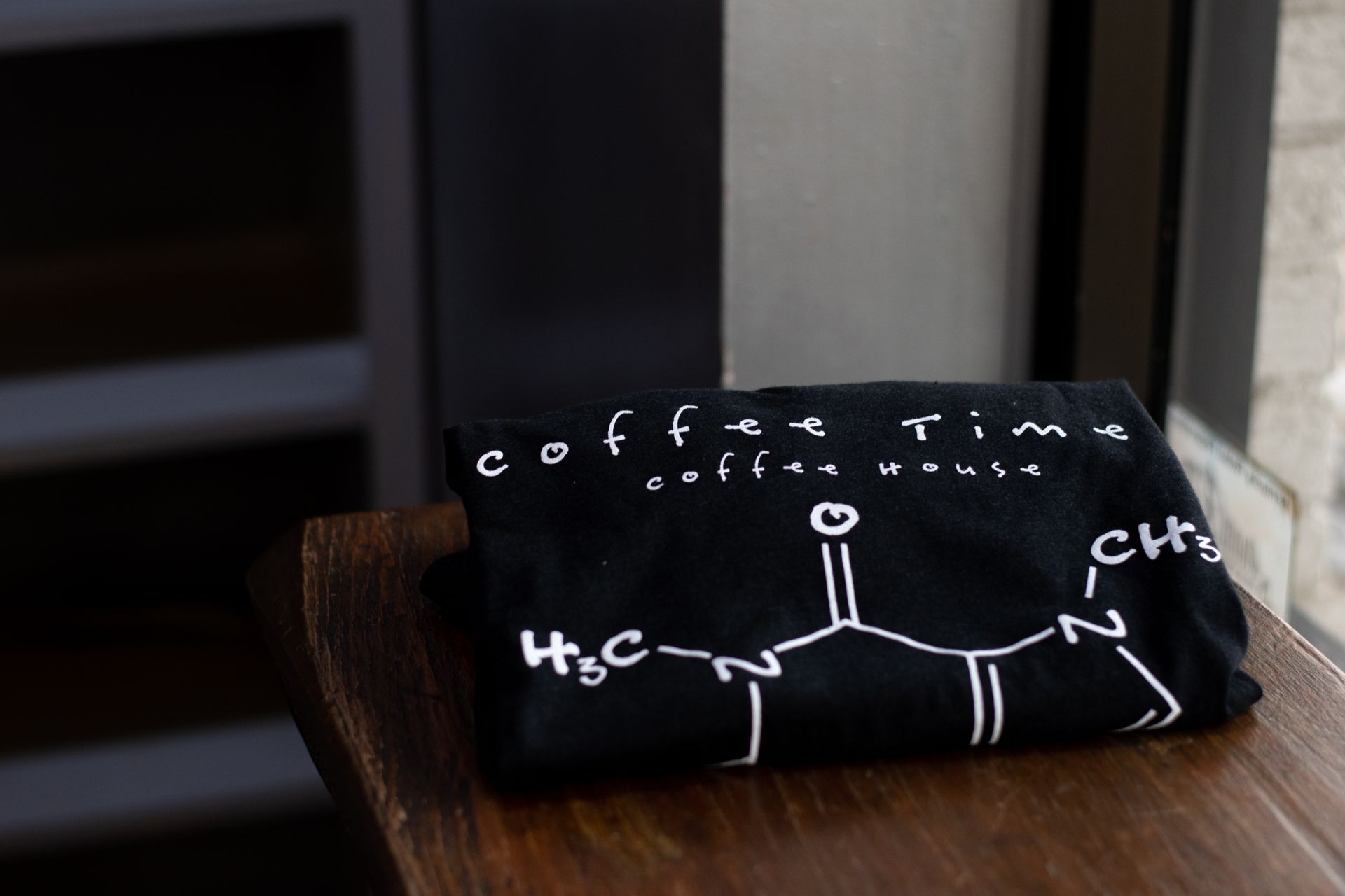 A black t-shirt sitting on top of a wooden table