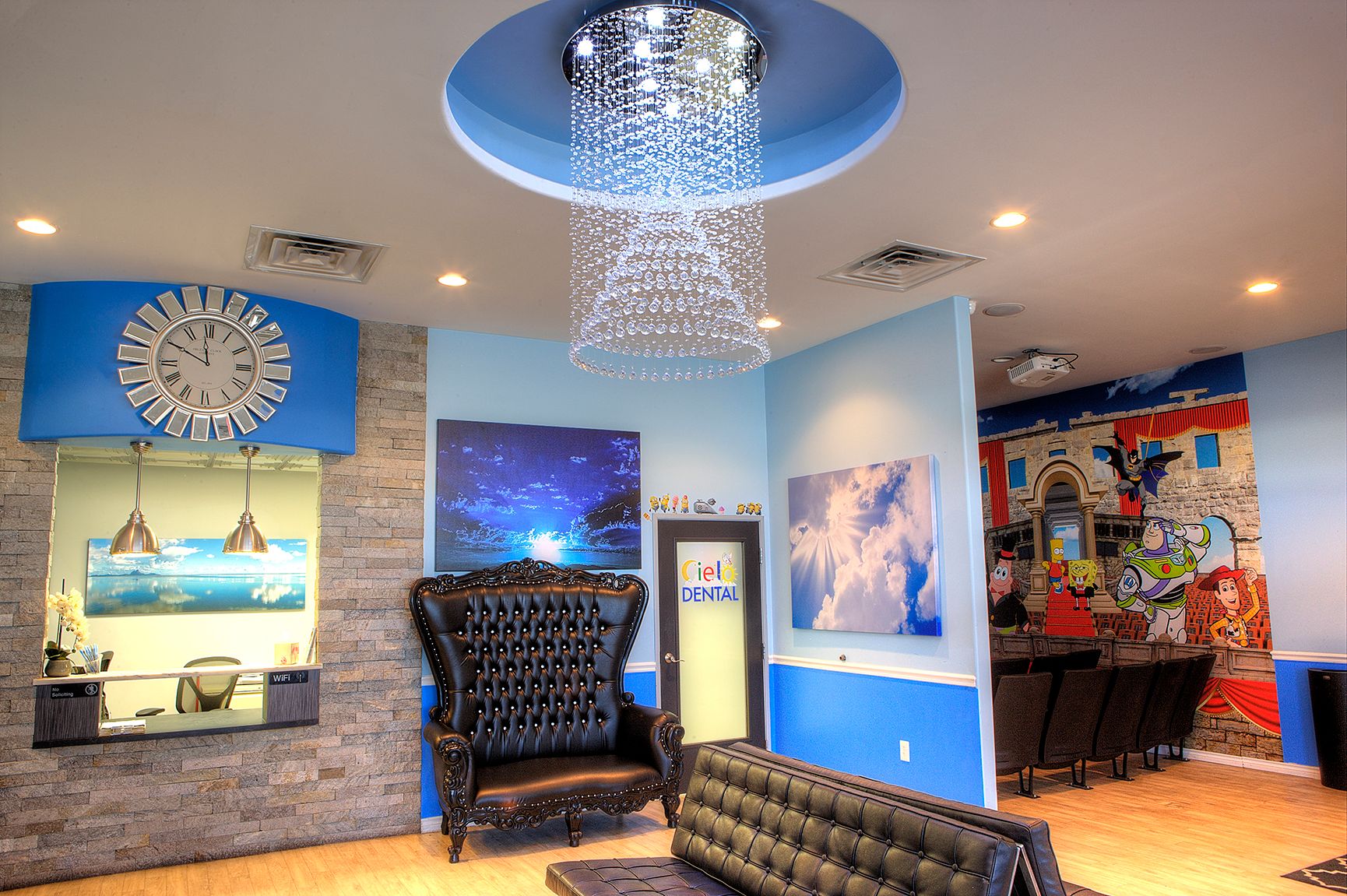 Cielo Dental, San Antonio. Lobby A room with a clock on the wall and a chandelier hanging from the ceiling