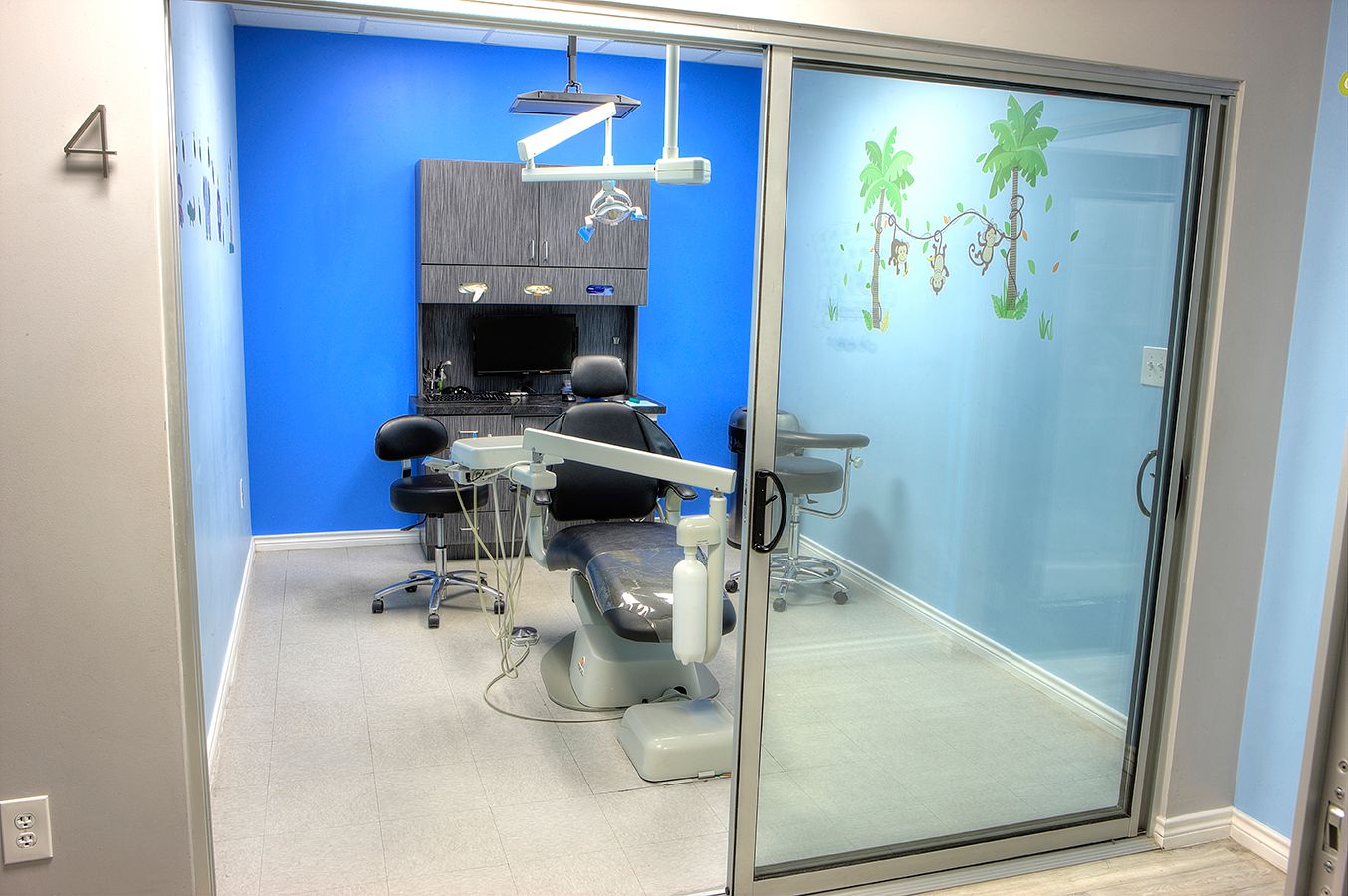 A dental office with a sliding glass door and a dental chair