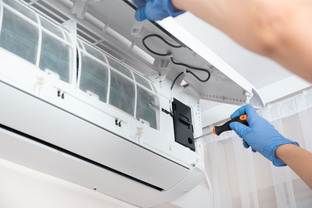 A Technician Repair an Air Conditioner Unit — Premiair Refrigeration, Air Conditioning & Electrical in Tamworth, NSW