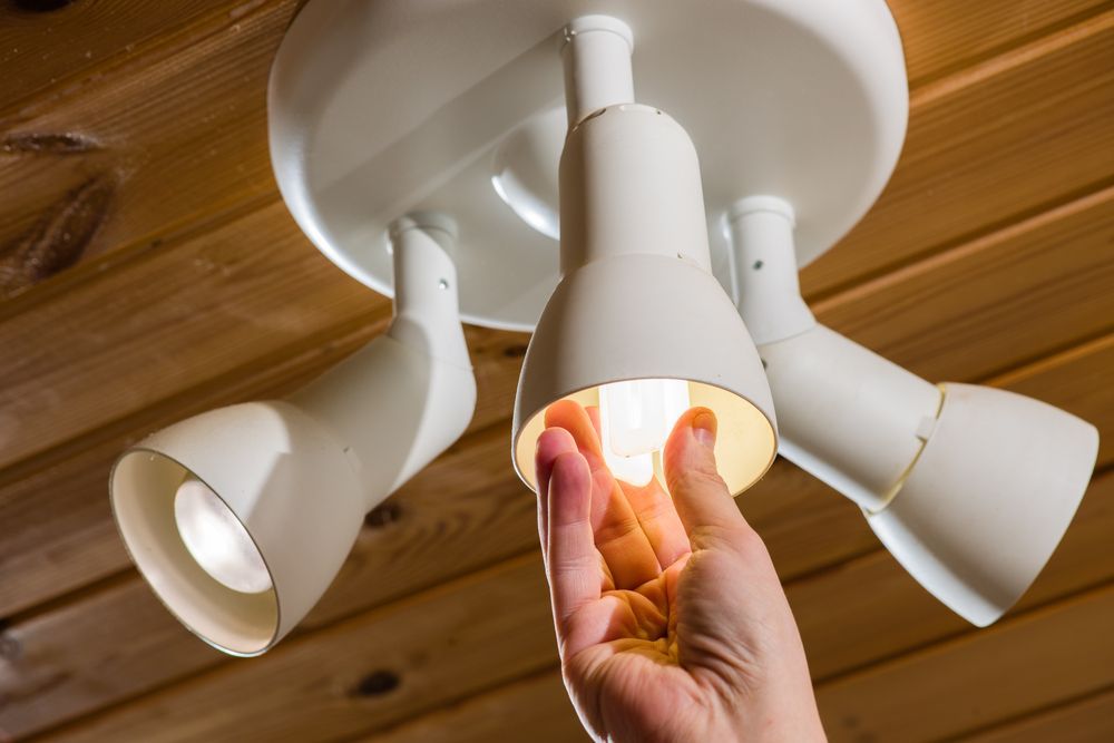 A Person Install a Lightbulb — Premiair Refrigeration, Air Conditioning & Electrical in Narrabri, NSW