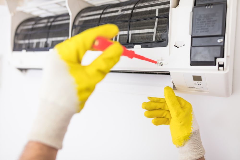 A Technician Repair a White Air Conditioner — Premiair Refrigeration, Air Conditioning & Electrical in Tamworth, NSW
