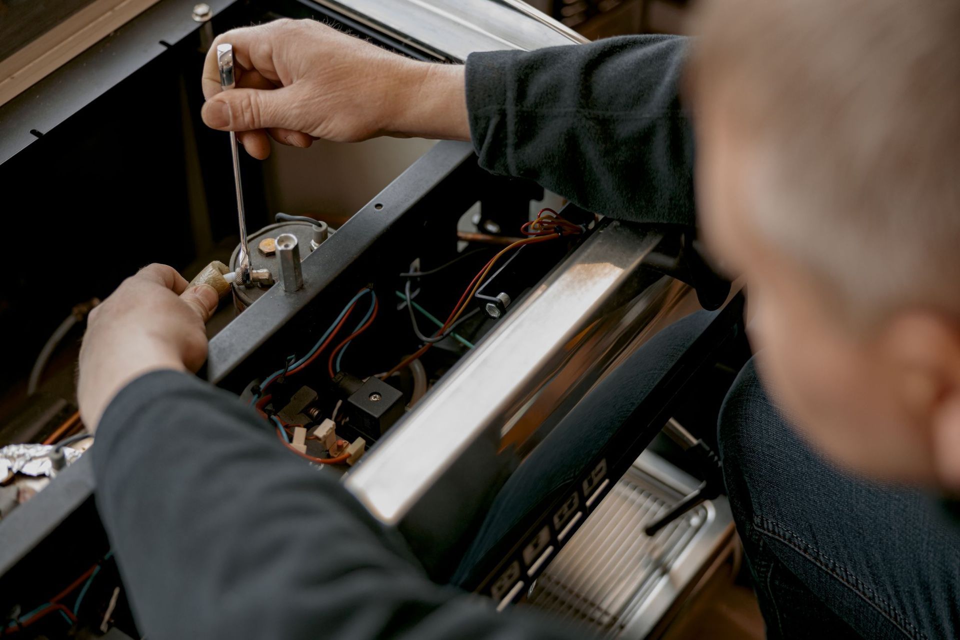 A Person Repair the Components of a Coffee Machine — Premiair Refrigeration, Air Conditioning & Electrical in Narrabri, NSW
