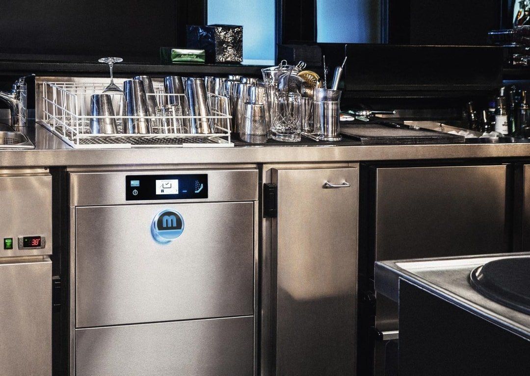 A Commercial Dishwasher Sits Under a Counter — Premiair Refrigeration, Air Conditioning & Electrical in Tamworth, NSW